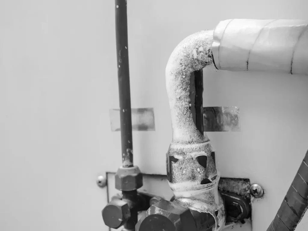 Frozen water pipes showing visible signs of ice buildup - symptoms of a frozen pipe