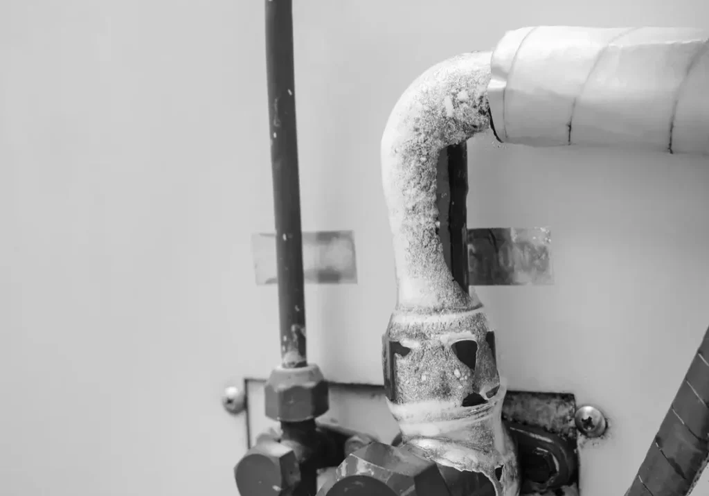 Frozen water pipes showing visible signs of ice buildup - symptoms of a frozen pipe
