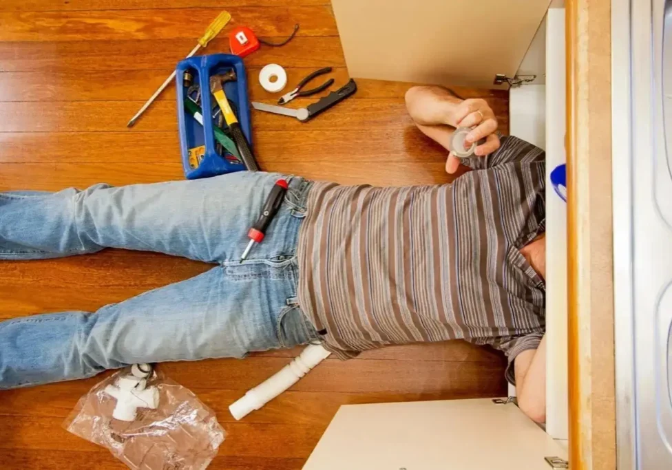 Plumber under kitchen sink