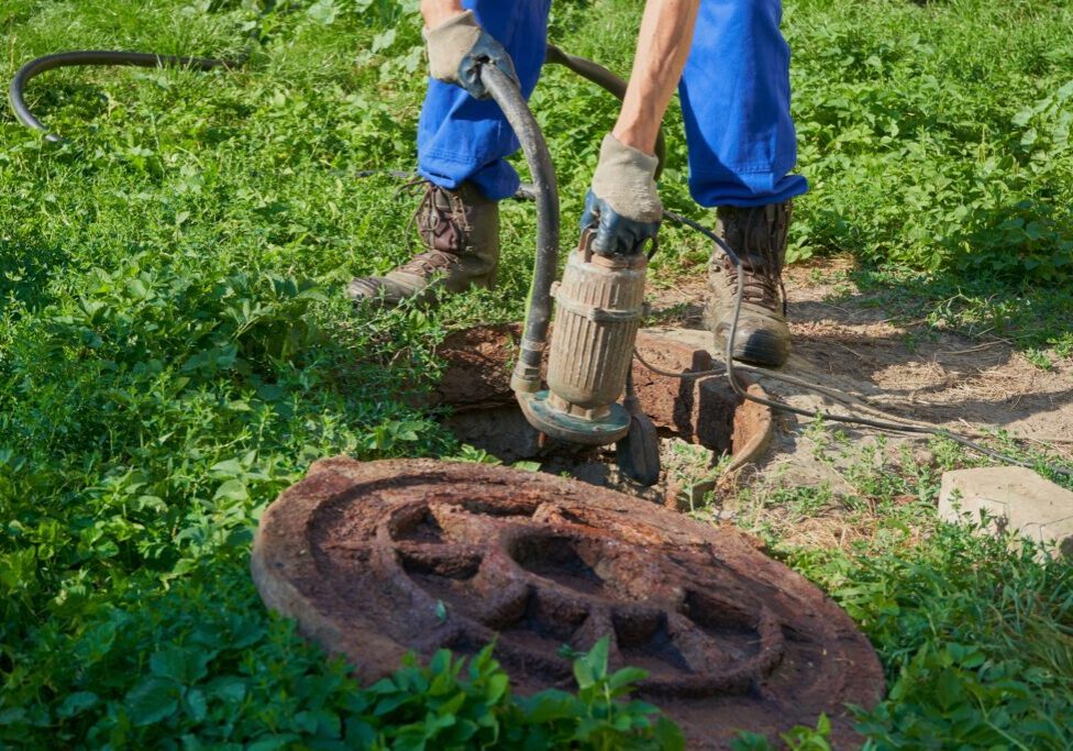 Plumber inspecting sump pump for repair